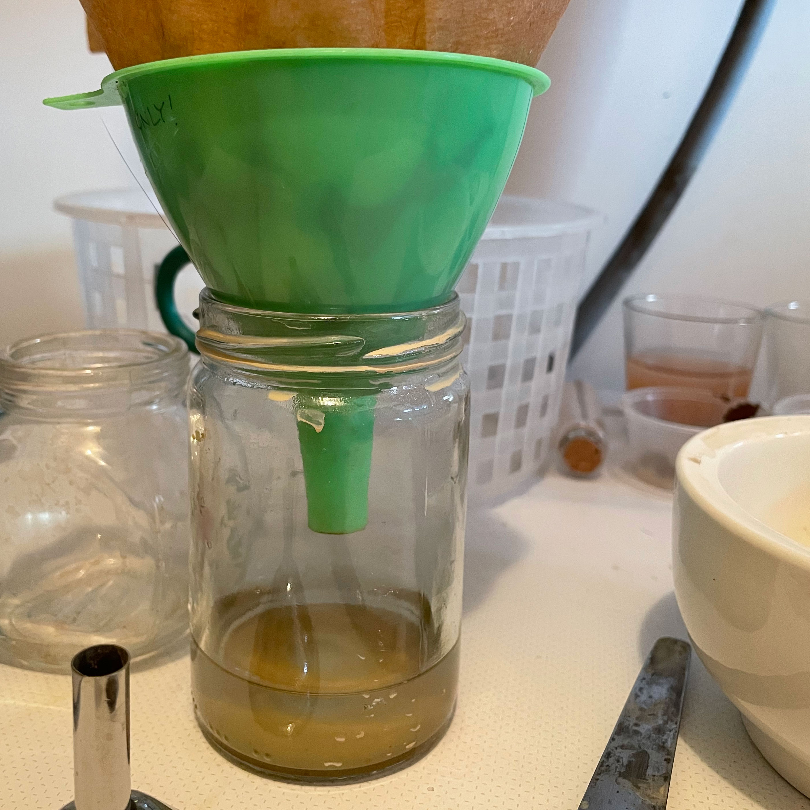 Filtering pigment through a coffee filter placed into a funnel.
